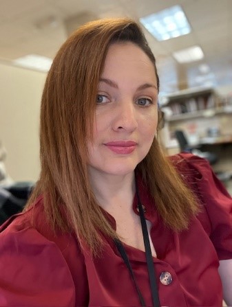 A person with red hair wearing a red shirt

Description automatically generated